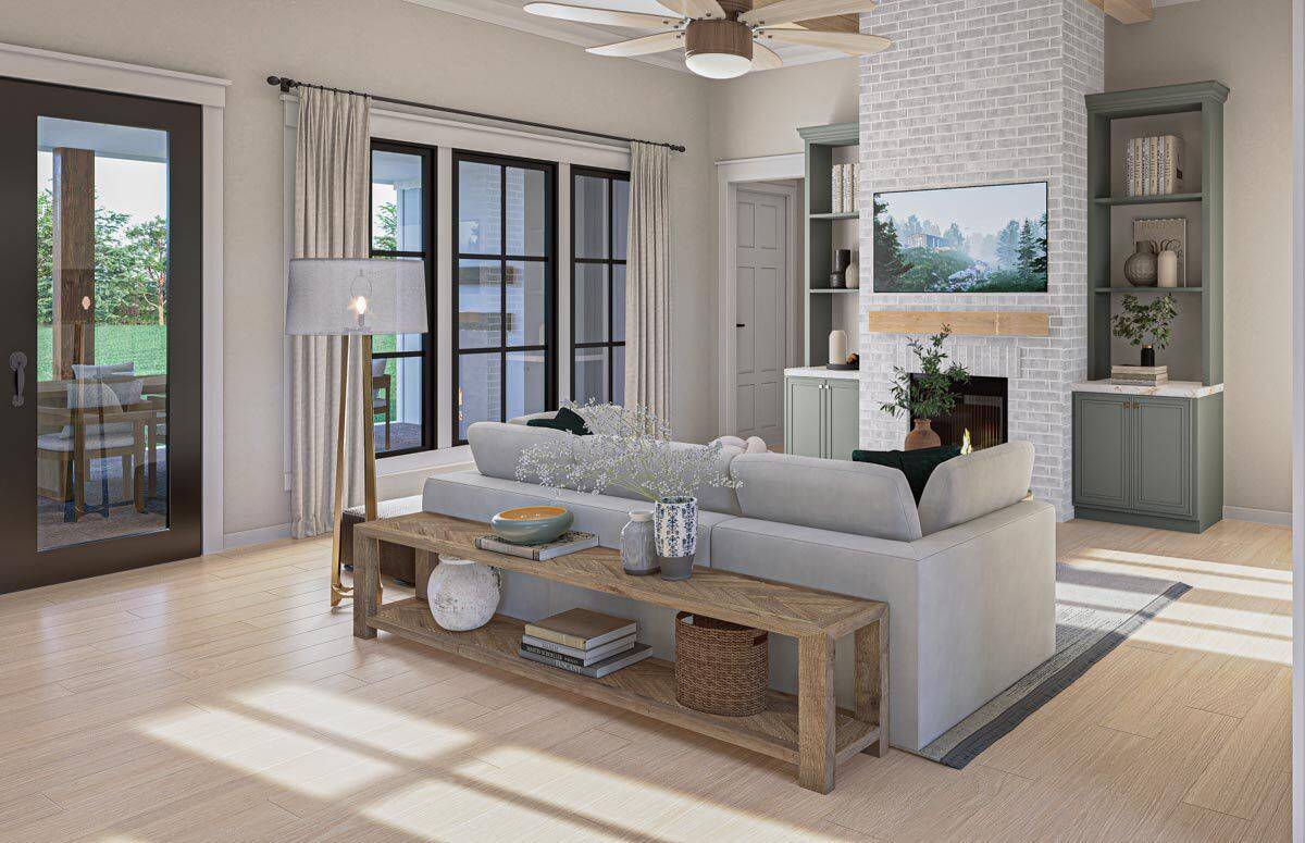 Great room with a sectional sofa and a brick fireplace flanked by tall cabinets.