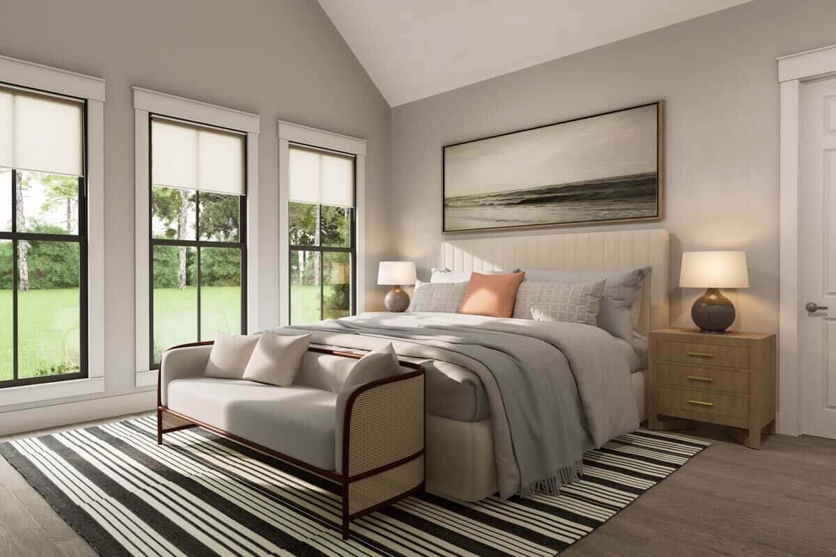 Primary bedroom with a vaulted ceiling, a platform bed, and a cushioned sofa over the striped area rug.