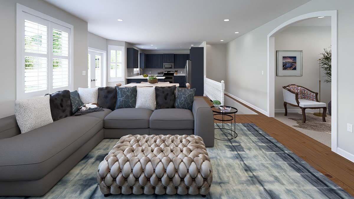 The family room includes a tufted ottoman sitting on a distressed area rug.