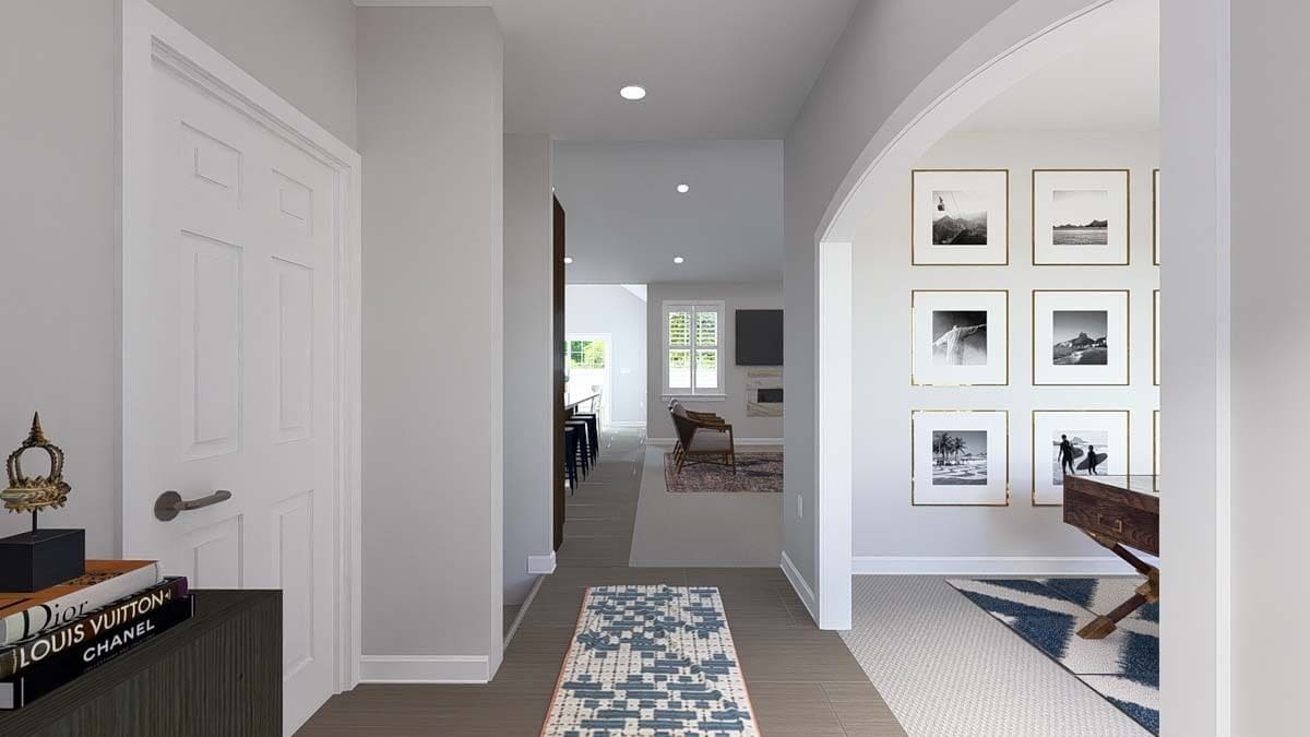 Foyer with a patterned runner and an archway on the side that opens to the study.