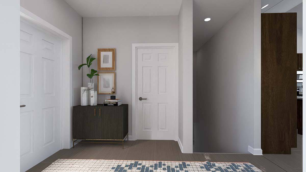 The foyer includes a wooden console table topped with vases and framed artworks.