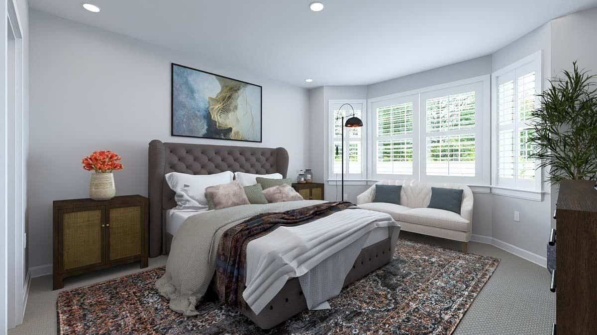 Primary bedroom with a tufted wingback bed and a sofa against the bay window.