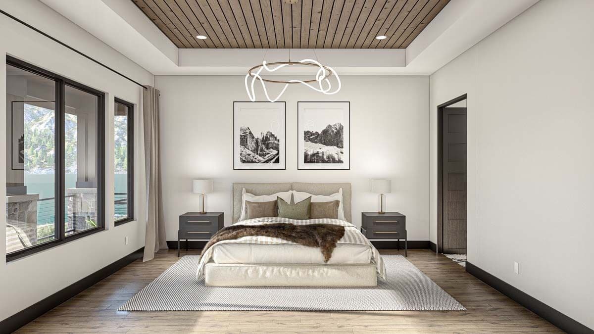 Primary bedroom with a tray ceiling, a platform bed, and sliding windows overlooking the rear deck.