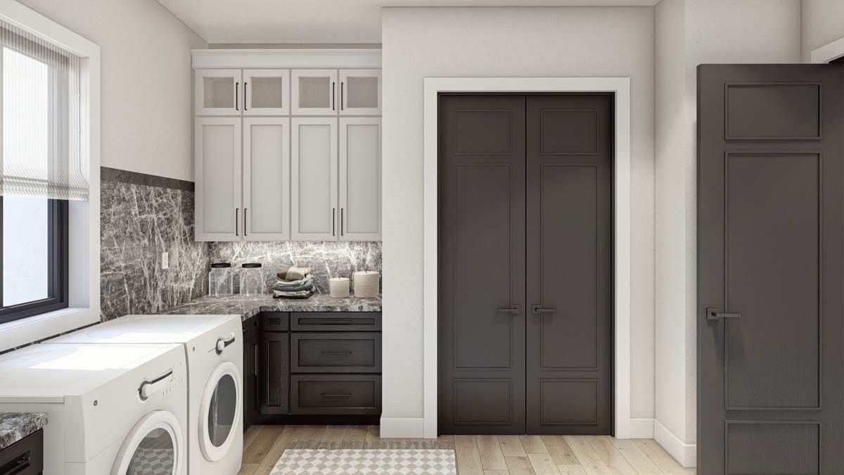 Laundry room with built-in cabinets and front-load appliances situated under the framed windows.