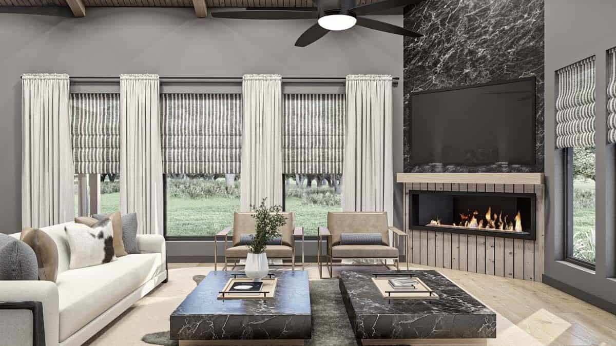 Great room with contemporary seats, marble coffee tables, and a corner fireplace with a TV on top.