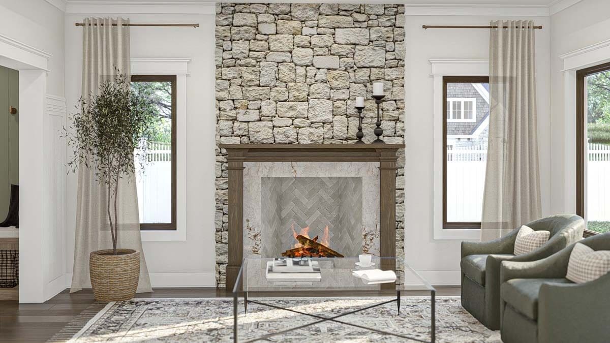 The great room includes a stone fireplace flanked by framed windows.