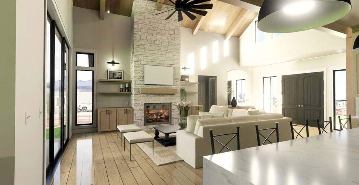 Great room with beige sofas, a stone fireplace, and a vaulted ceiling lined with exposed beams.