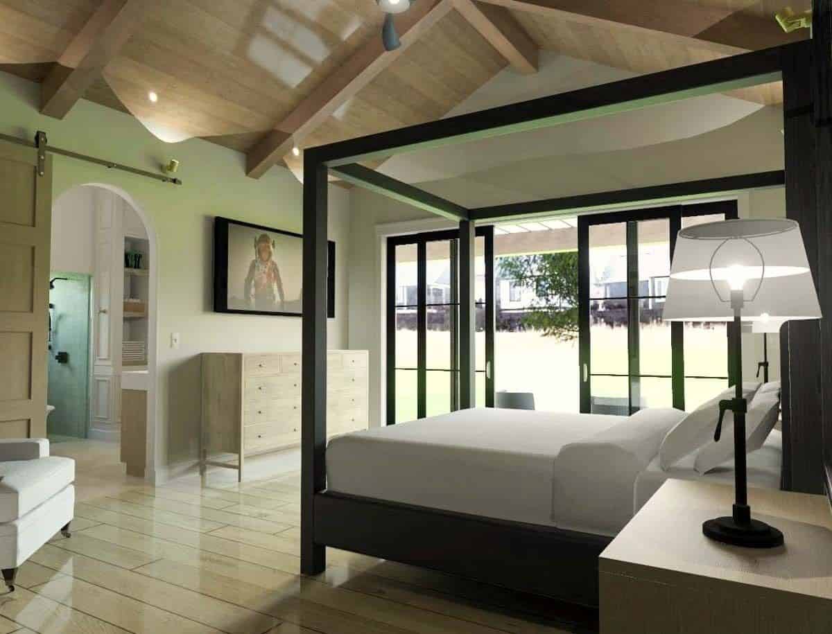 Primary bedroom with a vaulted ceiling, an ensuite bath, a canopy bed, and outdoor access through sliding glass doors.