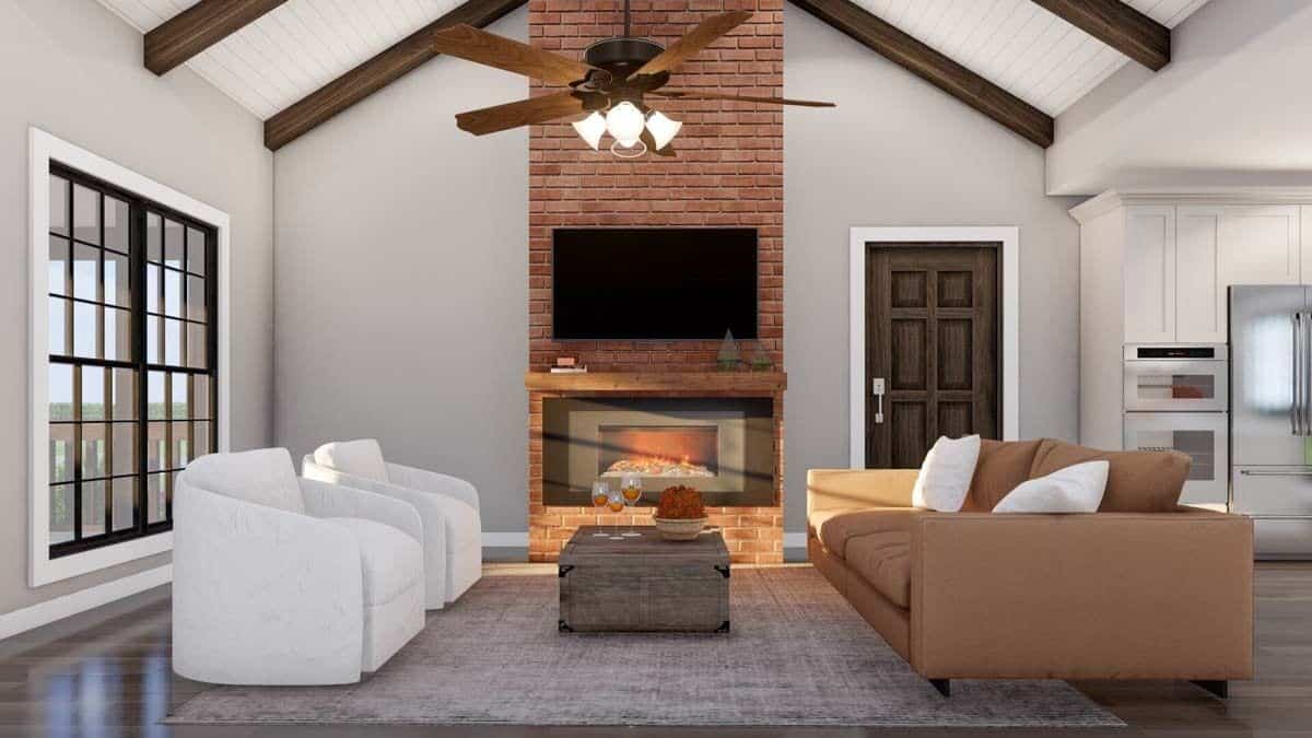 Great room with modern seats, a brick fireplace, and a cathedral ceiling accentuated with exposed beams.