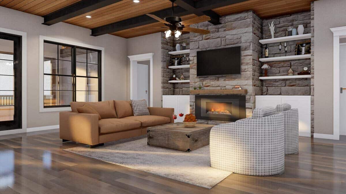 Great room with a sectional sofa, round back chairs, and a stone fireplace topped with a TV.