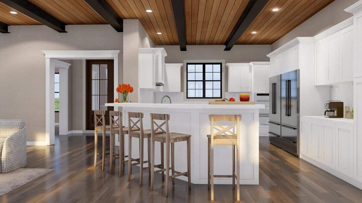 Kitchen with white cabinets and an angled peninsula bar paired with wooden bar stools.