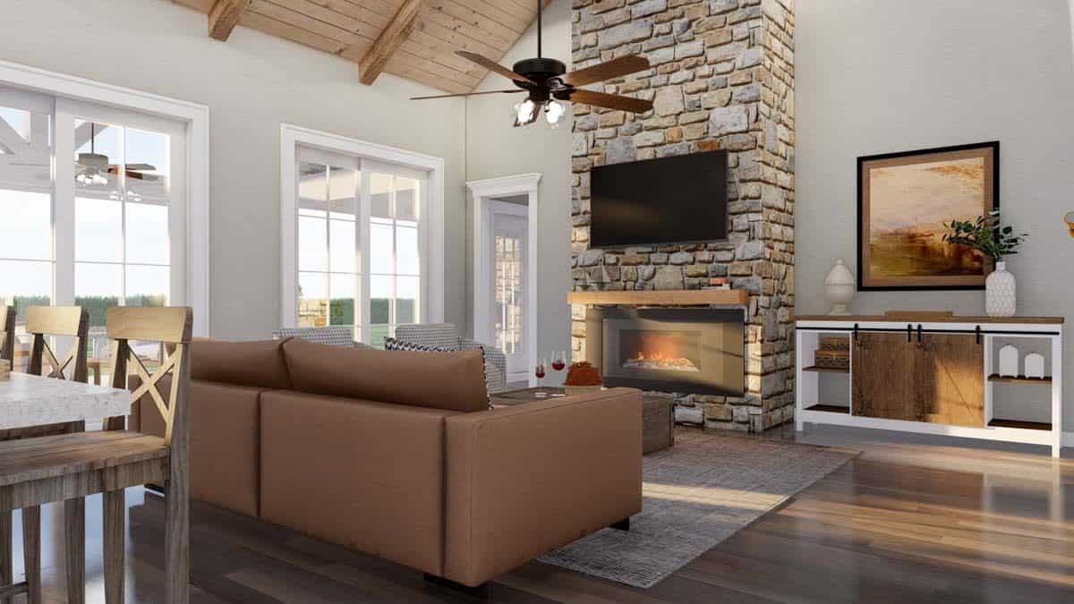 Great room with a sectional sofa and a stone fireplace topped with a TV.