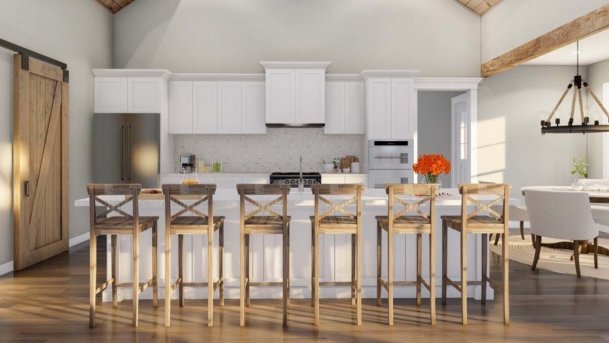 Kitchen with white cabinetry and a matching island paired with wooden bar stools.