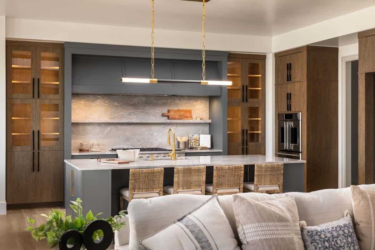Kitchen with glass-front cabinets and an elongated island paired with rattan counter chairs.