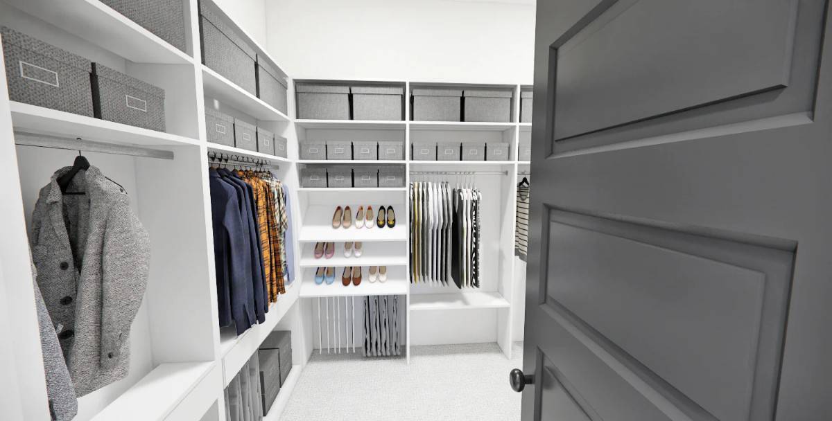 Primary walk-in closet with white built-ins and a carpeted floor.