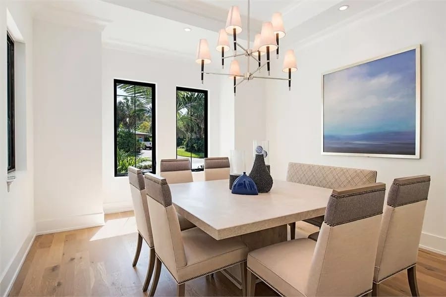 Dining room with a contemporary dining set illuminated by a warm chandelier.