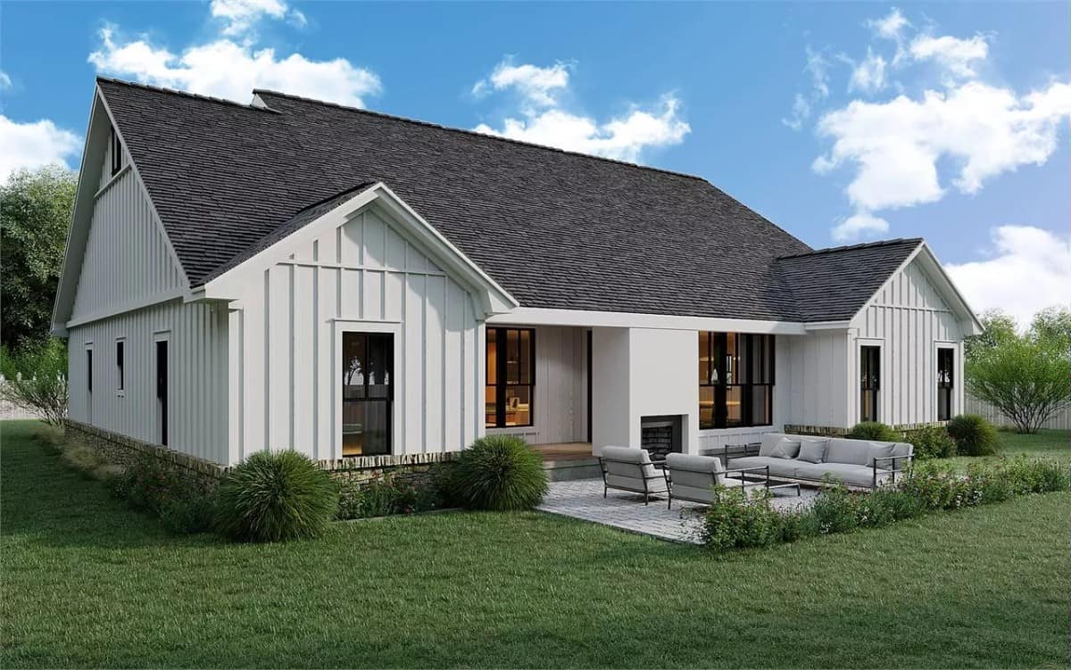 Rear view of the house with an open patio warmed by an outdoor fireplace.