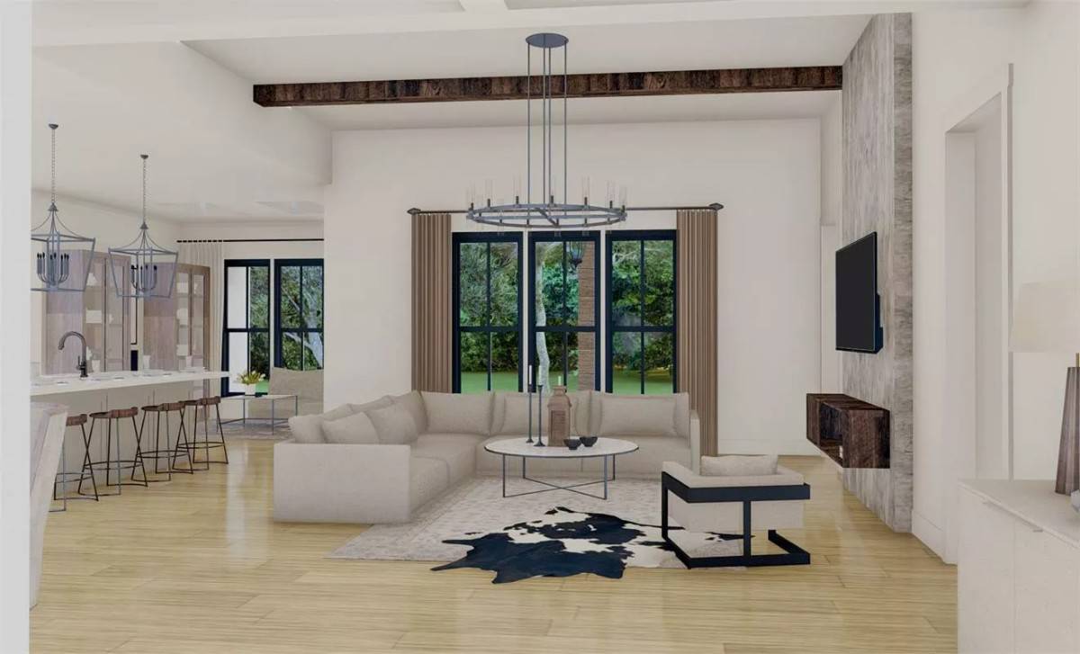Great room with an L-shaped sectional, a round coffee table, and a modern armchair over the cowhide rug.
