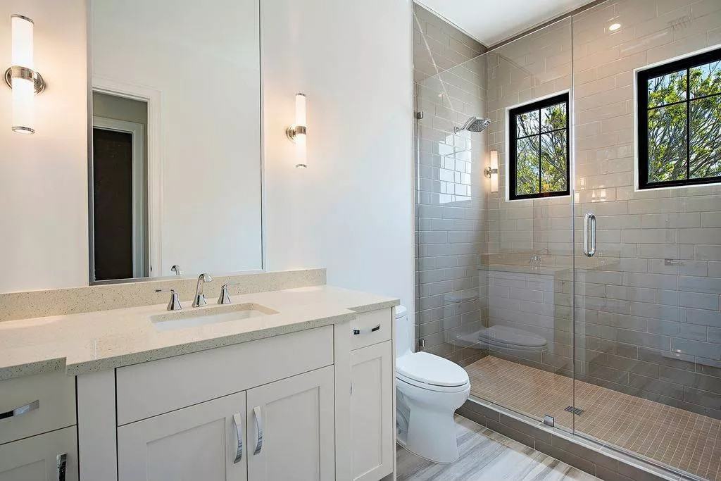 Bathroom with a sink vanity, a toilet, and a walk-in shower.