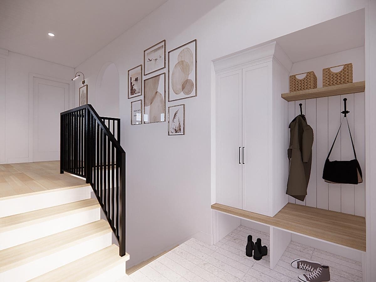 Foyer with built-in storage, a bench, coat hooks, and a staircase.
