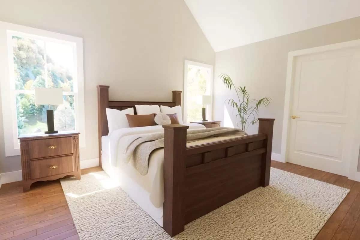 Primary bedroom with a wooden bed and matching nightstands under the cathedral ceiling.