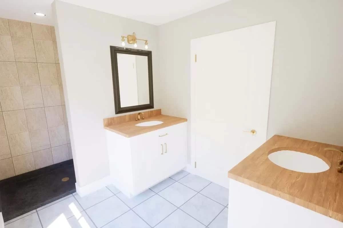 Primary bathroom with his and her sink vanities, and a walk-in shower.