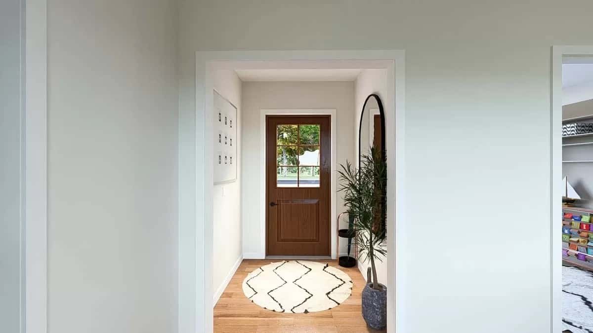 Foyer with a glazed front door and a round rug over the hardwood floor.