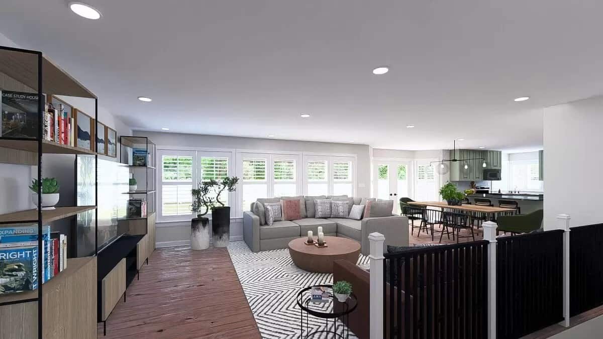 An open layout view of the family room, dining area, and kitchen brightened by a rear wall of windows.