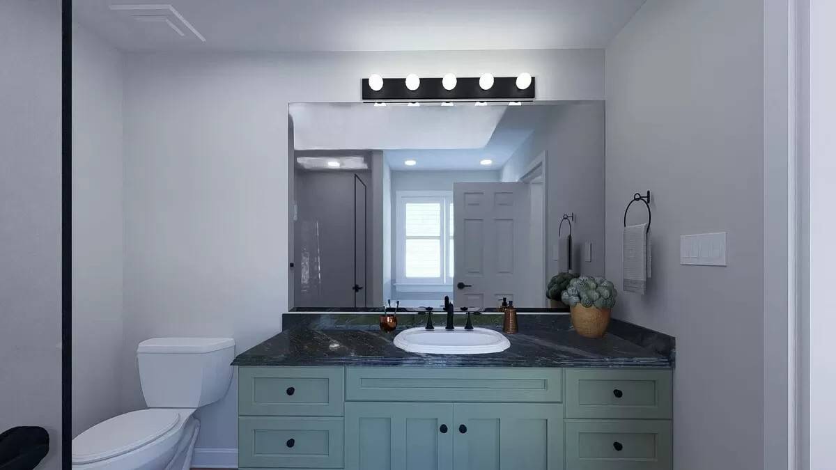 Primary bathroom with a toilet and a sink vanity paired with a frameless mirror.