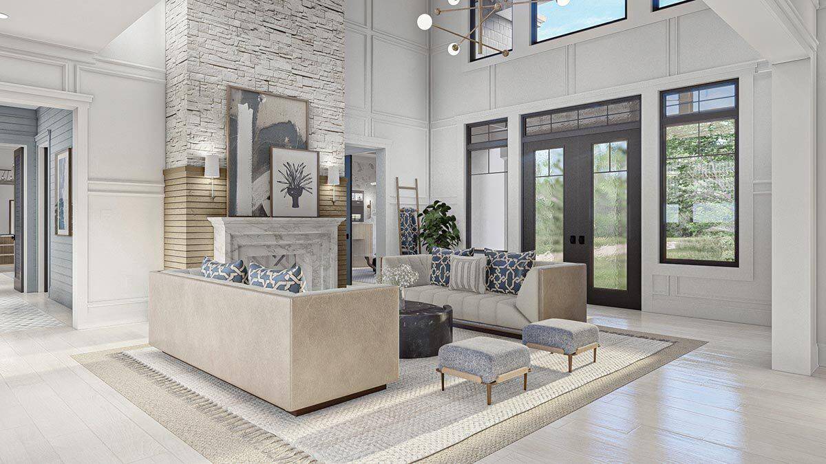 Great room with facing sofas and a marble fireplace adorned with framed paintings.