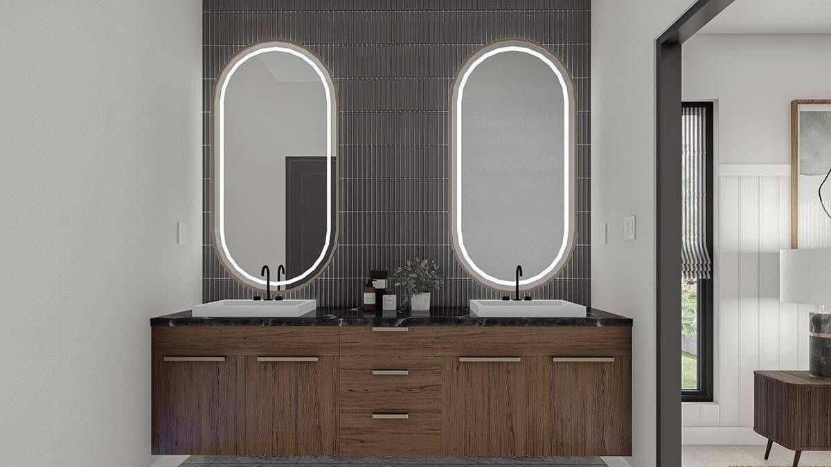 Primary vanity with two sinks, wooden cabinets, and illuminating oval mirrors.