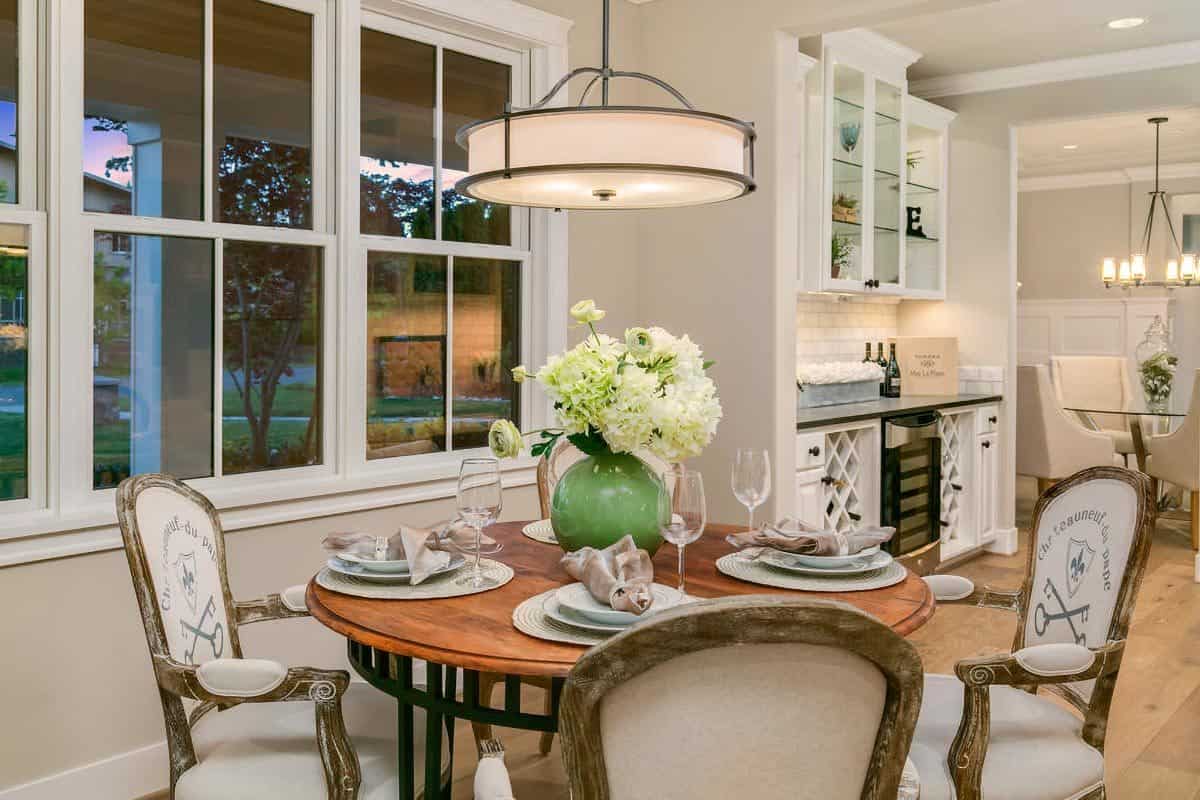 Breakfast nook with a round dining table surrounded by round back chairs.