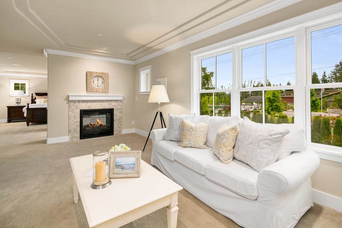 Sitting room with a skirted sofa and a double-sided fireplace.