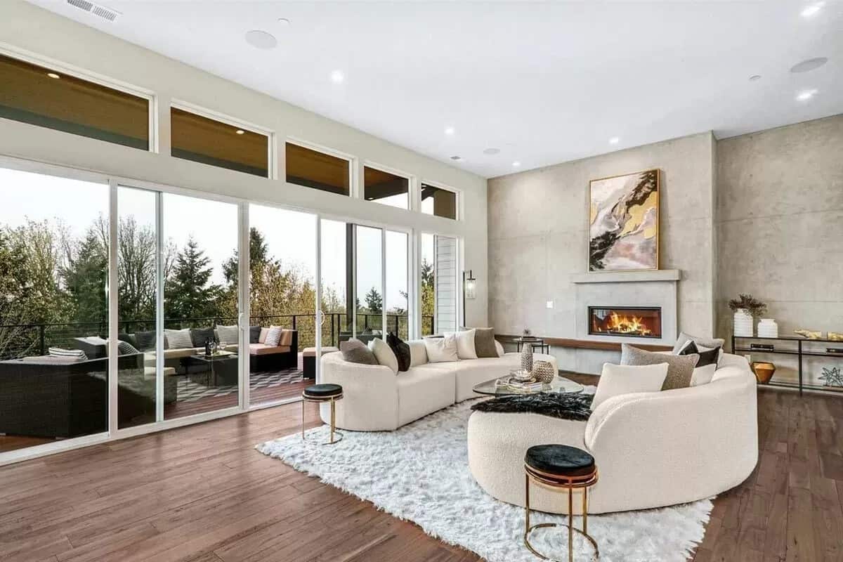 Great room with curved sofas, a fireplace, and sliding glass doors that open to a covered deck.