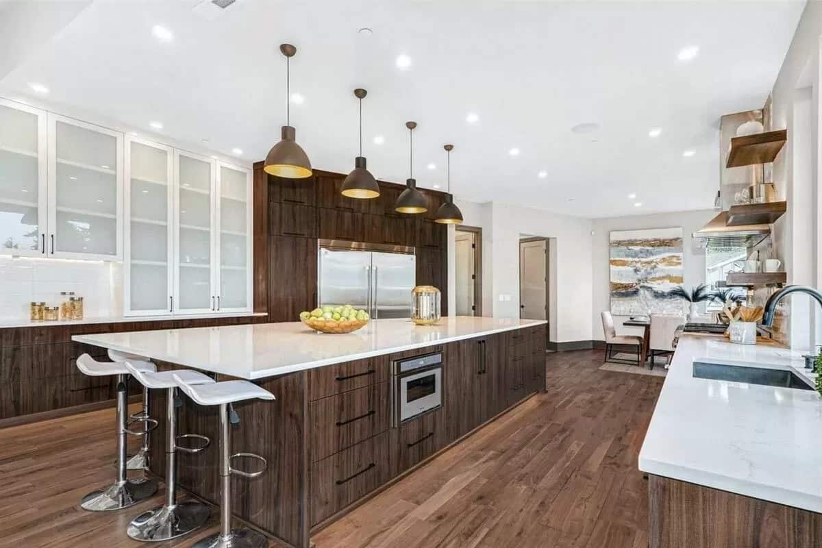 Kitchen with dark wood cabinets and a center island with bar seating.