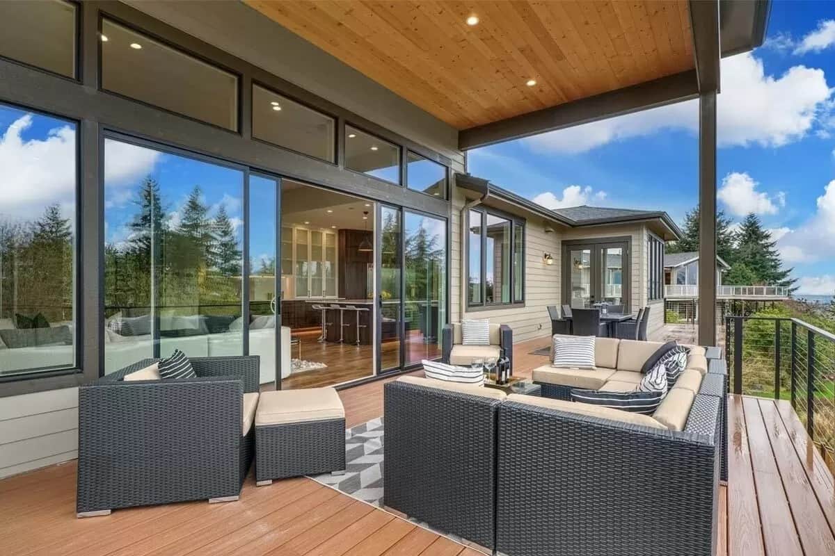 Covered deck with wicker seats and sliding glass doors.