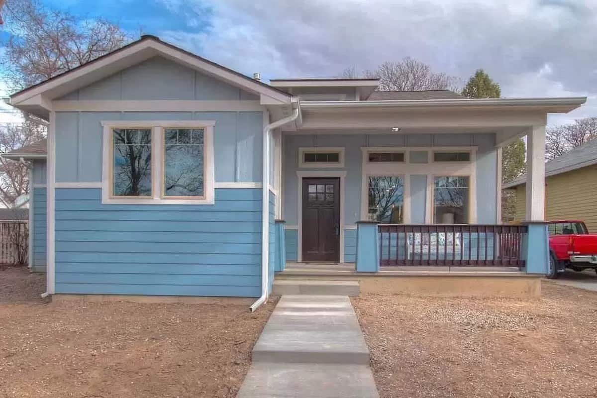 Front view of the house with a covered entry porch topped with a shed dormer.
