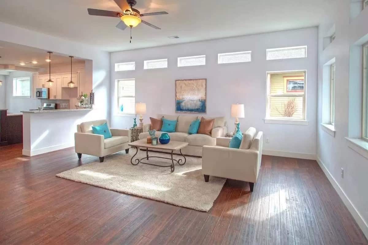 Living room with beige seats and an ornate coffee table over the shag area rug.