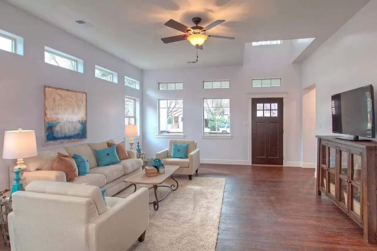 The living room includes a TV sitting on a wooden cabinet.