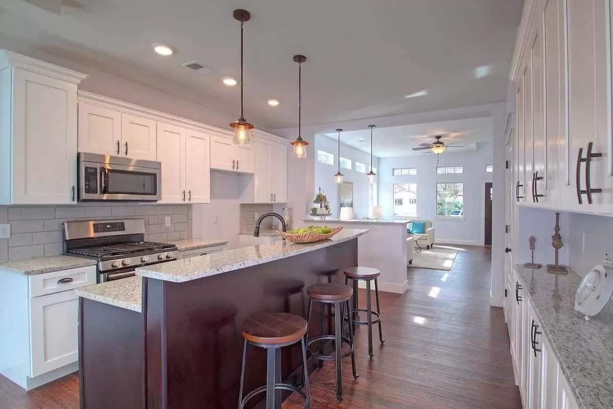 The kitchen includes white cabinets, modern appliances, and granite countertops.
