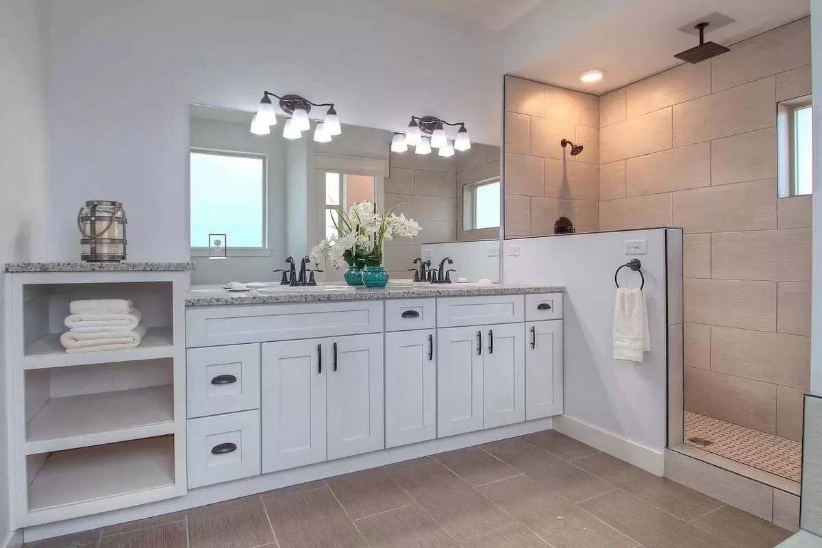 Primary bathroom with a dual sink vanity and a tiled shower.