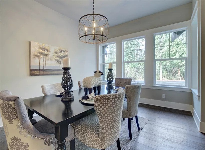 Dining room with a black dining table surrounded by wingback chairs.