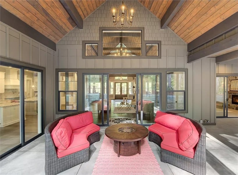 Outdoor living with wicker sofas and a round coffee table under the cathedral ceiling.