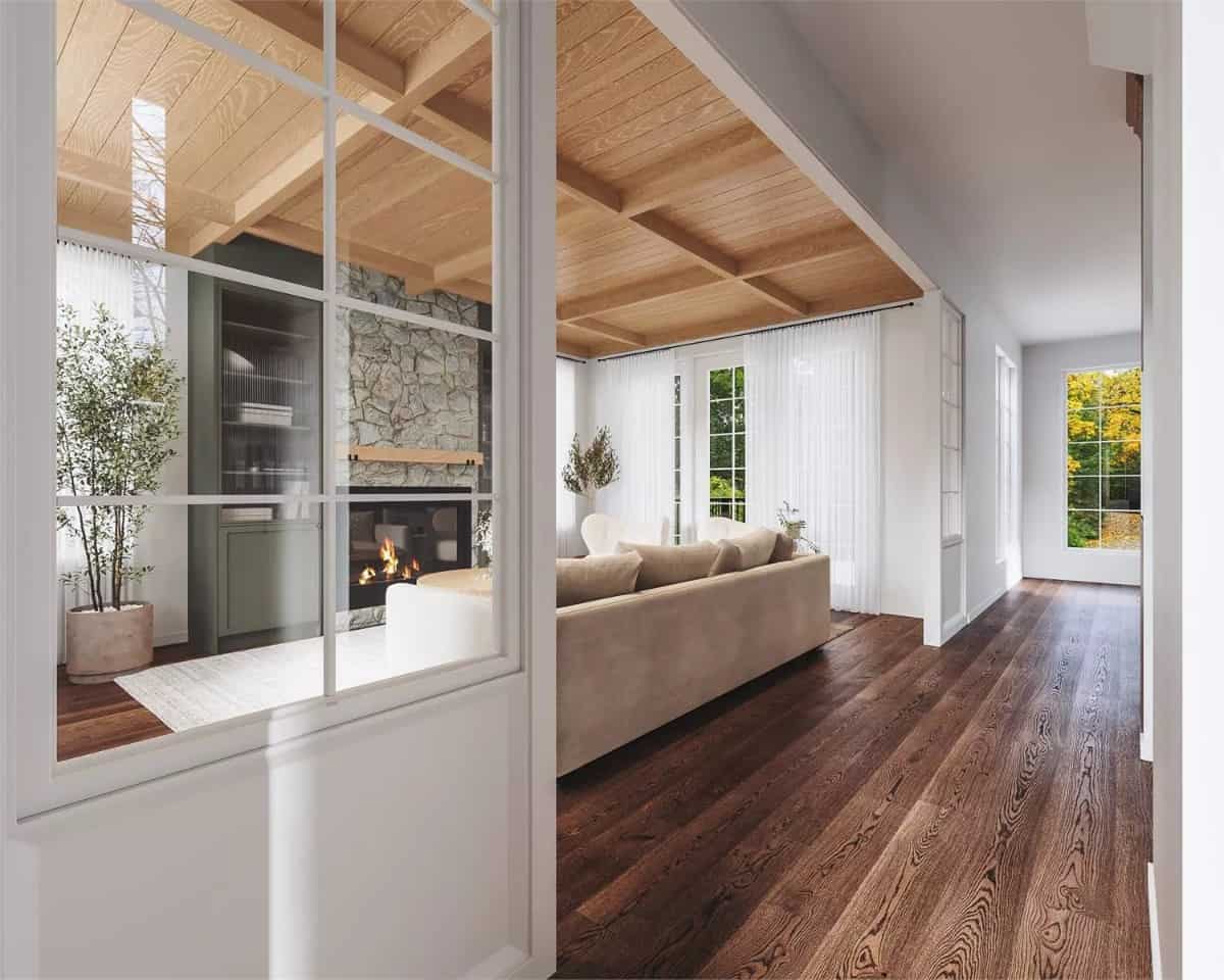Living room with white-framed windows and a wood-paneled ceiling accentuated with exposed wood beams.