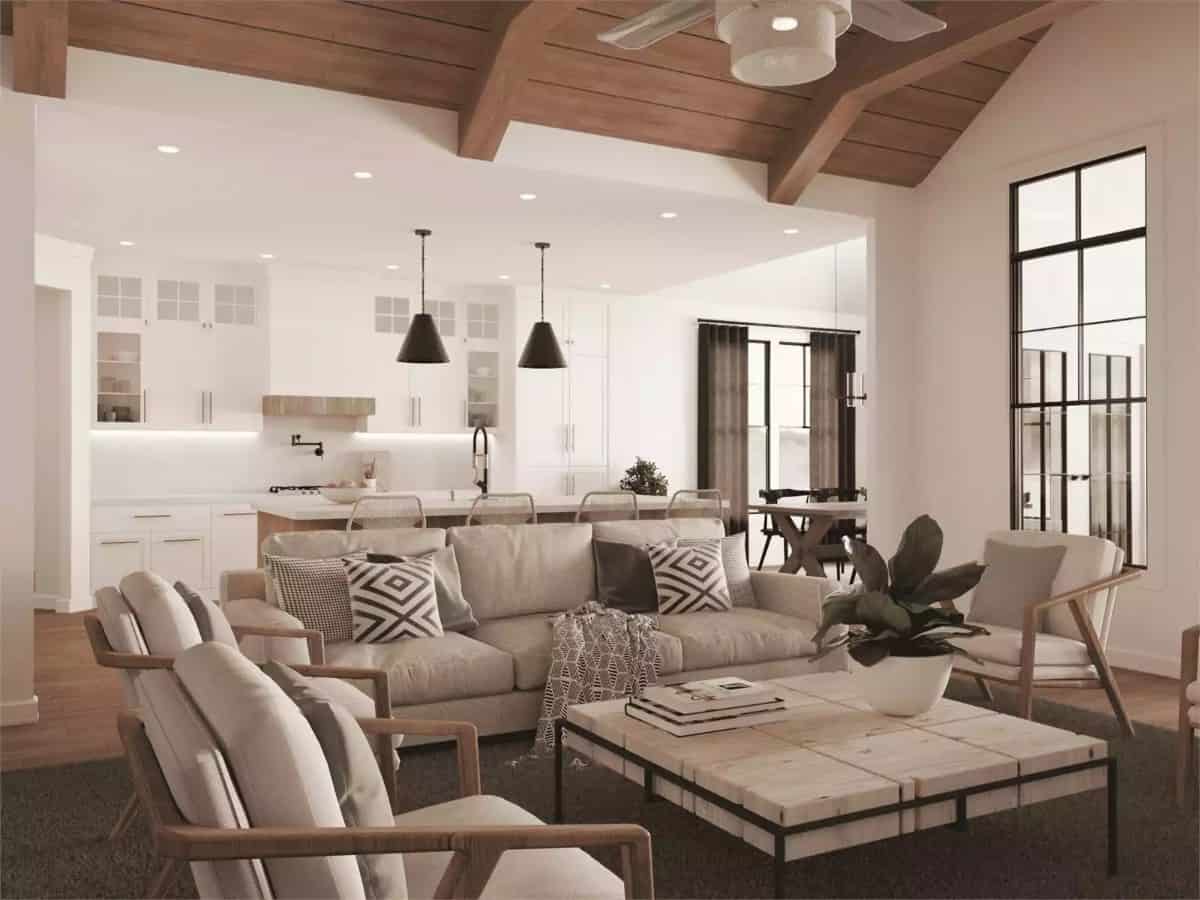 The living room includes cushioned seats and a rustic coffee table over the gray area rug.