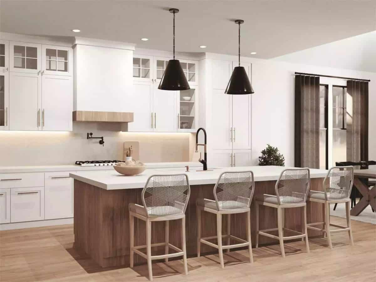 Kitchen with white cabinetry and a breakfast island fitted with a prep sink.