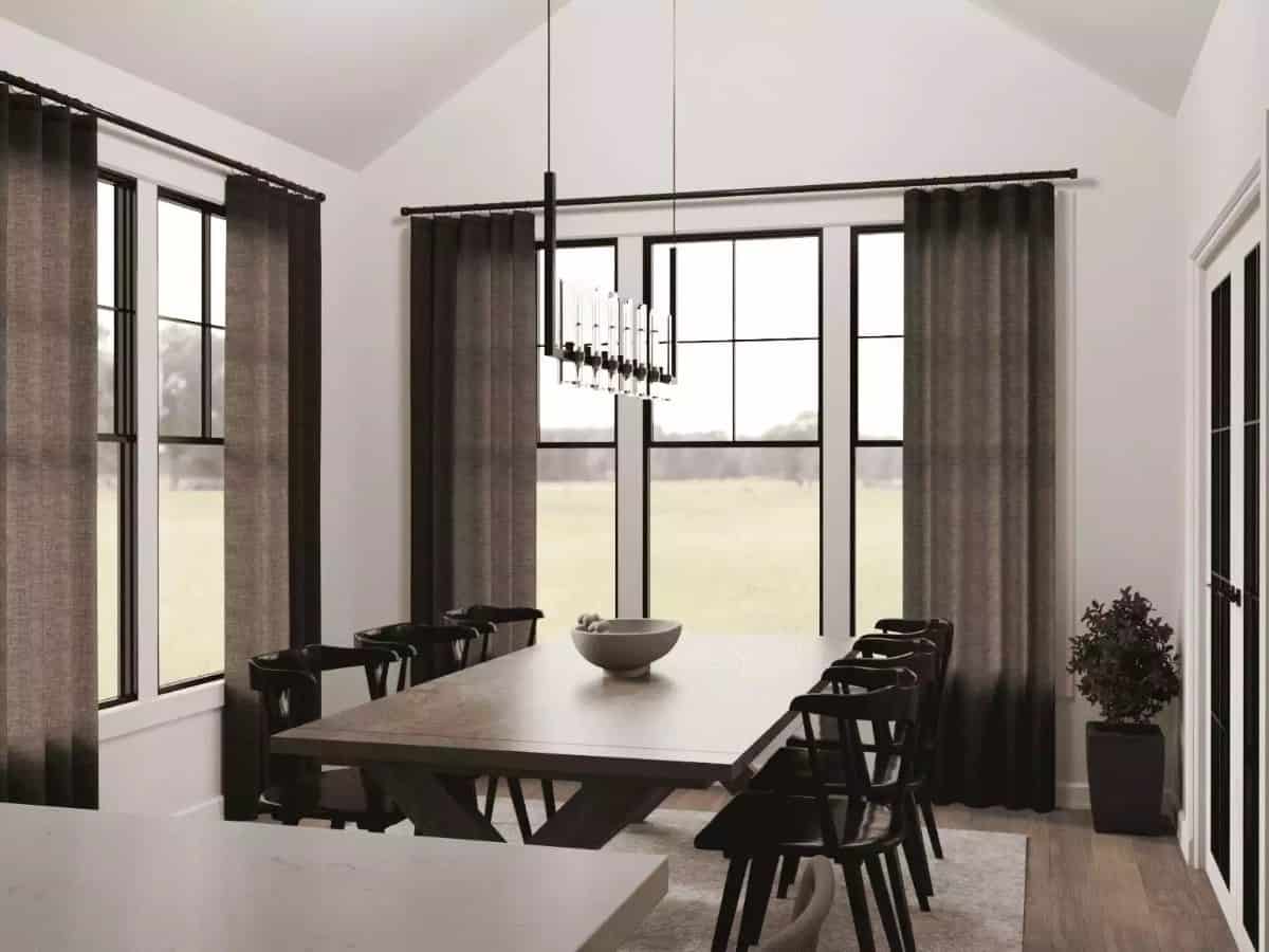 Dining area with a dark wood dining set and surrounding windows overlooking the backyard.