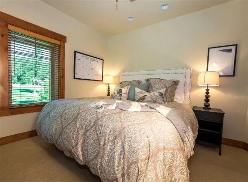 Primary bedroom with a carpeted floor and beige walls lined with wooden base moldings.