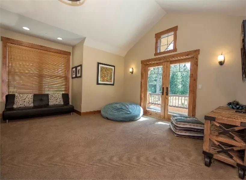 Playroom with a vaulted ceiling and a French door that opens to a covered deck.