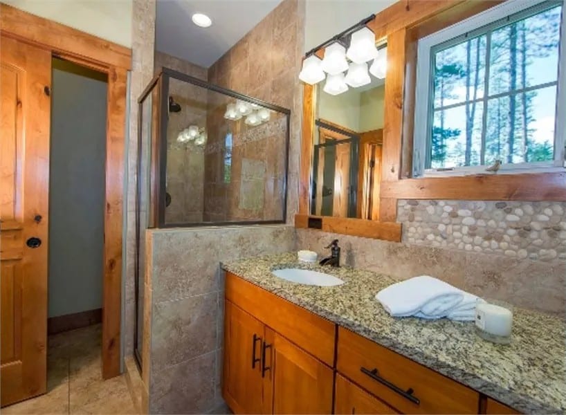 Primary bathroom with a walk-in shower, a toilet room, and a dual sink vanity.